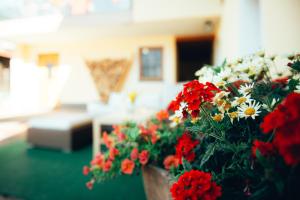 um vaso de flores vermelhas e brancas numa sala de estar em Ferienhotel Almajur em Mittelberg