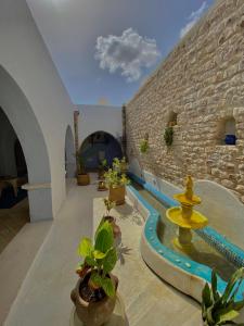 Villa con piscina y pared de ladrillo en Hôtel Djerba Authentique - Au centre de Midoun, en Midoun