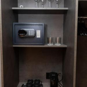 a kitchen shelf with a pay phone and glasses on it at Hotel Halond in Akureyri