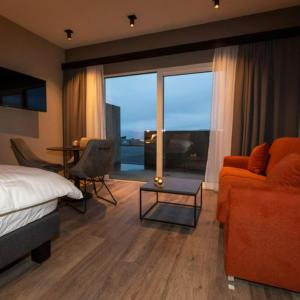 a bedroom with a bed and a couch and a table at Hotel Halond in Akureyri