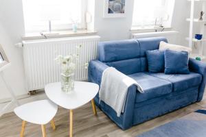 ein blaues Sofa im Wohnzimmer mit einem Tisch in der Unterkunft Kleines Kunsthaus. in Nordhausen