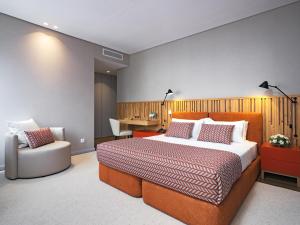 Villa Termal Monchique - Hotel Central - by Unlock Hotels في مونشيك: غرفة نوم بسرير ومكتب وكرسي