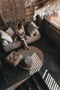 a woman sitting on a couch in a room at Jufenalm BOHO Hotel & Restaurant in Maria Alm am Steinernen Meer