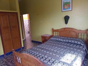 a bedroom with a wooden bed and a door at Suerte Loca in Sidi Ifni