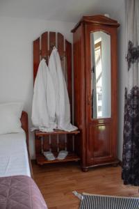 a bedroom with a bed and a cabinet with white sheets at Pensiunea Ricky in Căpăţîneni-Ungureni