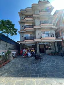 a group of people sitting outside of a building at Hotel Sandalwood in Pokhara