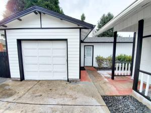 eine Garage mit einer weißen Garagentür an einem Haus in der Unterkunft Relax & Enjoy This Spacious Gem In Easy Location in Vancouver