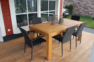 una mesa de madera y sillas en una terraza en Kleiner Onkel en Twist