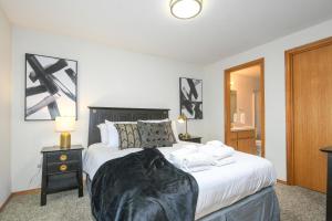 1 dormitorio con cama blanca y cabecero negro en Cozy Couve Apartment Close To Everything!, en Vancouver