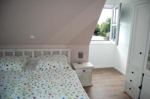 a white bedroom with a bed and a window at Kleiner Onkel in Twist