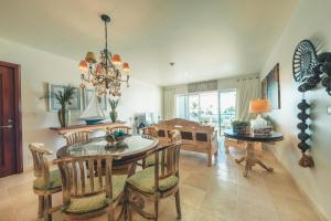 a dining room with a table and chairs and a chandelier at Punta Palmera Beachfront Apartment in Punta Cana