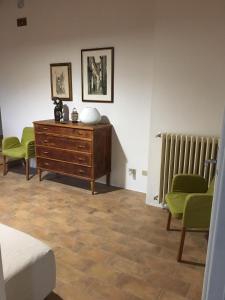 una camera da letto con cassettiera, due sedie e un termosifone di Tenuta Cà Di Bertucci a Solignano