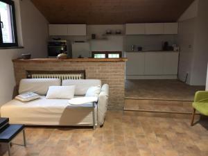 un soggiorno con divano bianco e una cucina di Tenuta Cà Di Bertucci a Solignano