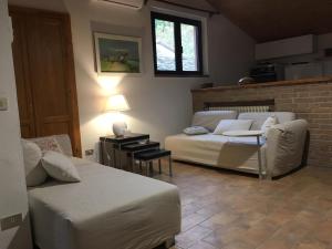 una camera con due letti, un divano e una finestra di Tenuta Cà Di Bertucci a Solignano