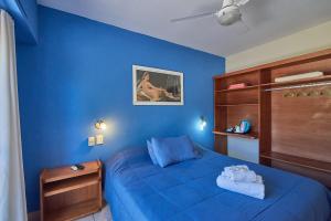 Dormitorio azul con cama y pared azul en El Molino - Complejo Turístisco en Victoria