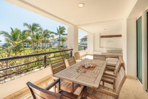 a balcony with a table and chairs and a view of the ocean at NEW 2BR Apt w Jacuzzi Punta Palmera CBA in Punta Cana
