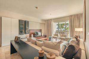 a living room with a couch and a table at NEW 2BR Apt w Jacuzzi Punta Palmera CBA in Punta Cana