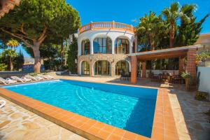a house with a swimming pool in front of a house at Villa Cintya - PlusHolidays in Ifach