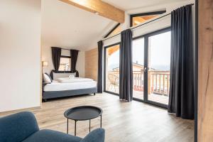 a bedroom with a bed and a large window at Inzell Chalets by ALPS RESORTS in Inzell