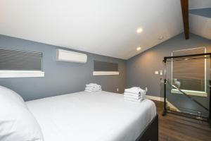 'couve Guesthouse Suite Close To Pdx في فانكوفر: غرفة نوم بسرير ابيض كبير و نافذتين