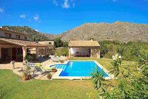 un patio trasero con piscina y una casa en Elegant Pollensa Villa Private Gardens Villa Cal Beato La Font, en Pollensa