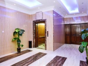a room with a hallway with a door and plants at Relax inn Apartment - Fahaheel in Kuwait