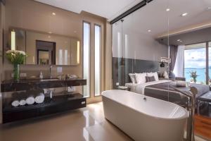 a bathroom with a tub and a bed and a bedroom at X10 Seaview Suites at Panwa Beach in Panwa Beach