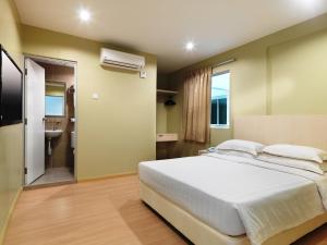 a bedroom with a large bed and a bathroom at Fenix Inn in Melaka