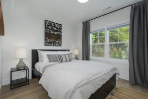 een witte slaapkamer met een bed en een raam bij Sunny Space In Walkable N'hood, 15min To Pdx in Camas