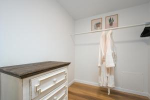 een kamer met een dressoir en een witte muur bij Bright & Modern Basement Apartment Dt N'hood in Vancouver