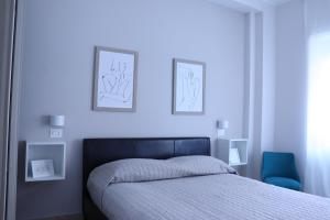 ein Schlafzimmer mit einem Bett und zwei Bildern an der Wand in der Unterkunft Due Passi dal Mare in Pescara