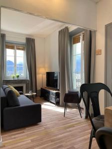 a living room with a couch and a television at Coeur d'Aix, vue splendide et cachet in Aix-les-Bains