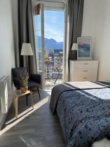 1 dormitorio con 1 cama, 1 silla y 1 ventana en Coeur d'Aix, vue splendide et cachet, en Aix-les-Bains
