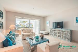 a living room with a couch and a tv at Ocean View 1 BR Apartment at Punta Palmera DB7 in Punta Cana