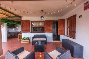 Finca con impresionantes vistas في لوس رياليخوس: غرفة معيشة مع أريكة وكراسي وطاولة