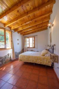 Finca con impresionantes vistas في لوس رياليخوس: غرفة نوم بسرير في غرفة بسقوف خشبية