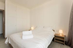 Una cama blanca con dos toallas blancas. en PanOrama View, Nilie Hospitality MGMT en Tesalónica