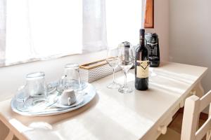 einen Tisch mit zwei Gläsern und einer Flasche Wein in der Unterkunft LA MASSARÌA agriresort in Orta Nova