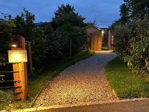 un cartel en un camino de grava junto a una valla en Cocklebury Farm, en Pewsey