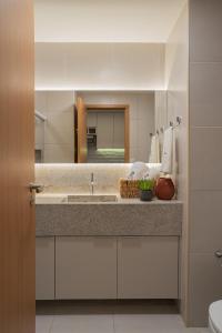 a bathroom with a sink and a large mirror at FLAT 210 - ECORESORT PRAIA DOS CARNEIROS in Tamandaré
