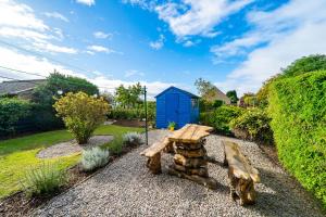 a bench in a garden with a blue shed at Riverview in Monifieth