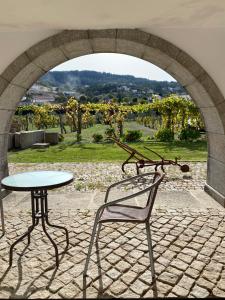 an archway with a table and a table and a chair at Casa de Santa Bárbara - Cinfães in Cinfães
