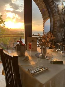 a table with a glass of wine and a view of the ocean at Il Tramonto in Shirokë