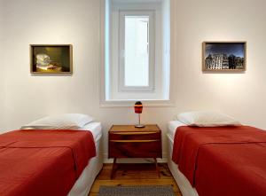 sypialnia z 2 łóżkami i oknem w obiekcie New Art Apartment w Lizbonie