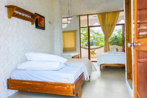- une chambre avec 2 lits et une fenêtre dans l'établissement Royal Galápagos Inn, à Puerto Baquerizo Moreno