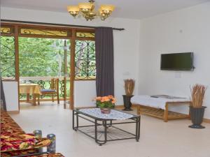 a living room with a tv and a table at Antonio's Residency Goa in Betalbatim