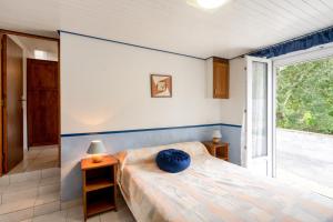 1 dormitorio con cama y ventana grande en Maison d'une chambre avec jardin clos a Beuzec Cap Sizun a 5 km de la plage, en Beuzec-Cap-Sizun