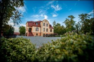 a large building in the middle of a park at Villa Natura in Dolsk