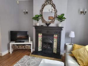 a living room with a fireplace and a mirror at Pebble Cottage in Worthing