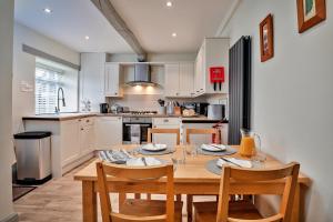 a kitchen with a wooden table and chairs in a kitchen at Finest Retreats - Cloggers Cottage in Darley